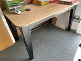 a wooden desk with a computer monitor and books on it