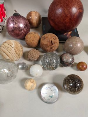 tout un tas de boules en verre de toutes sortes posées sur une table