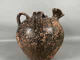 une image représentant un vase noir et marron sur fond blanc