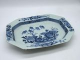 a blue and white plate with a bird and flowers on it