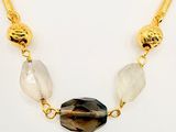 gold plated necklace with black and white stones and a golden chain
