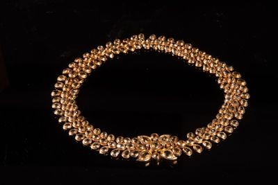 gros plan d'un collier en or sur fond noir