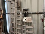 several ladders are leaning against a wall in a garage