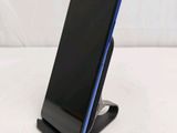 a close up of a cell phone on a stand on a white surface