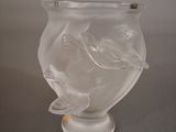 un vase en verre orné d'un oiseau, posé sur une table