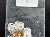 a bag of white and gold brooches on a black table