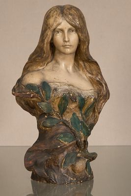 statue d'une femme aux cheveux longs posée sur une table en verre