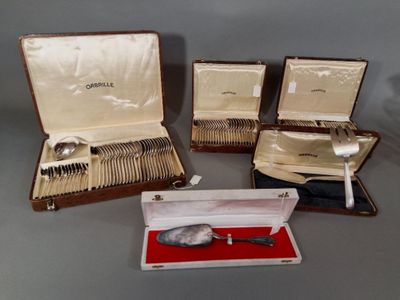 trois valises ouvertes contenant de l'argenterie, posées sur une table