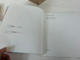 a person holding a book open on a table