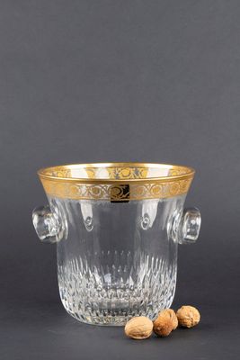 un verre à vin avec un bord doré et deux noix posées sur le côté