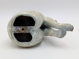 a sculpture of a dog that is inside of a hole
