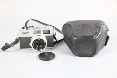 a camera and a coin on a white surface