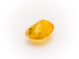 a yellow sapphire stone on a white background