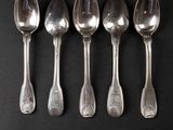 six silver spoons and a fork on a black surface