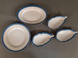 four blue and white dishes are arranged on a gray surface