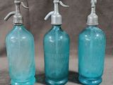 three blue glass bottles with soap dispensers sitting on a table