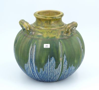 a green and blue vase with a tag on it