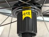 un gros plan d'une roue de vélo sur laquelle est collé un autocollant jaune