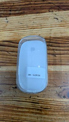 a white apple mouse sitting on a wooden table