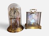 two clocks sitting next to each other on a white surface