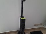 un aspirateur posé par terre à côté d'un tapis