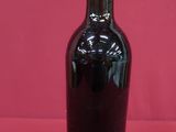 a bottle of wine sitting on a red surface