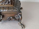a bronze clock sitting on top of a table
