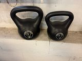 two kettlebells sitting on a shelf in a gym