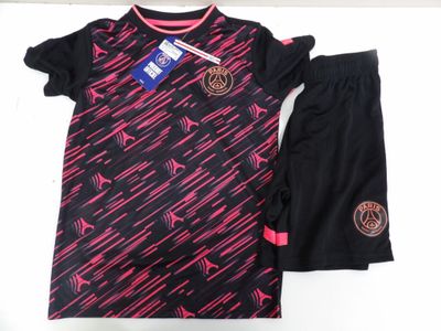 un gros plan d'un t-shirt et d'un short posés sur une surface blanche