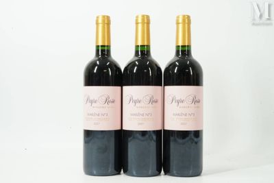 trois bouteilles de vin posées sur une table blanche