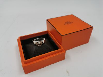 une boîte orange contenant une bague, posée sur une surface blanche