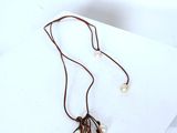 necklace with pearls and leather cord on white background