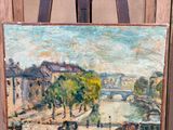 une peinture à l'huile représentant une scène urbaine, posée sur un chevalet devant un immeuble
