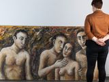 une femme debout devant un tableau représentant trois hommes nus