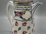 une image représentant une cafetière décorée de fleurs