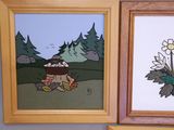 two framed pictures on the wall of a bathroom