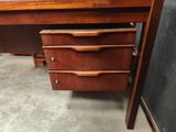 a wooden desk with three drawers and a chalk board