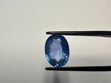 a close up of a blue sapphire being held by a pliers