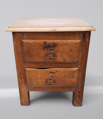 une vieille table en bois avec deux tiroirs et un tiroir posé dessus