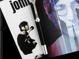 a book with a picture of john lennon and a pen