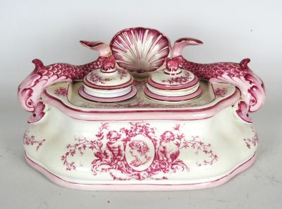 une boîte rose et blanche surmontée d'un coquillage
