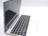 a white laptop with a black keyboard on a white surface
