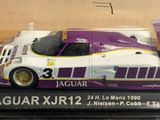 purple and white model of a racing car in a plastic case