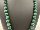 a green beaded necklace on a mannequin display