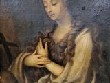 un vieux tableau représentant une femme tenant un oiseau dans ses mains