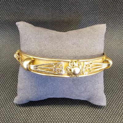 un gros plan sur un bracelet en or orné d'un cœur