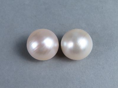 deux perles blanches posées sur une surface grise