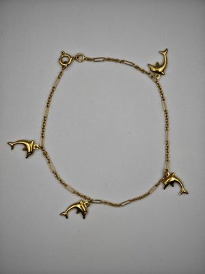 un bracelet en or orné de dauphins et d'étoiles