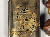 a small metal case with a gold dragon on it