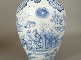 a blue and white vase with a picture of people in a boat
